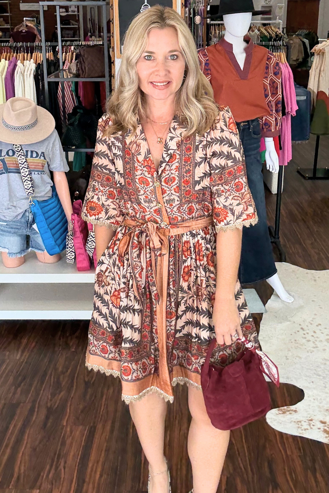 This lightweight botanical print mini dress features short puff sleeves and delicate lace trim at the hem and sleeves for a subtle touch of elegance. Designed with a button-front closure, contrast trim, and an elasticated back waist for a flattering fit, it includes a removable self belt and convenient side pockets.
