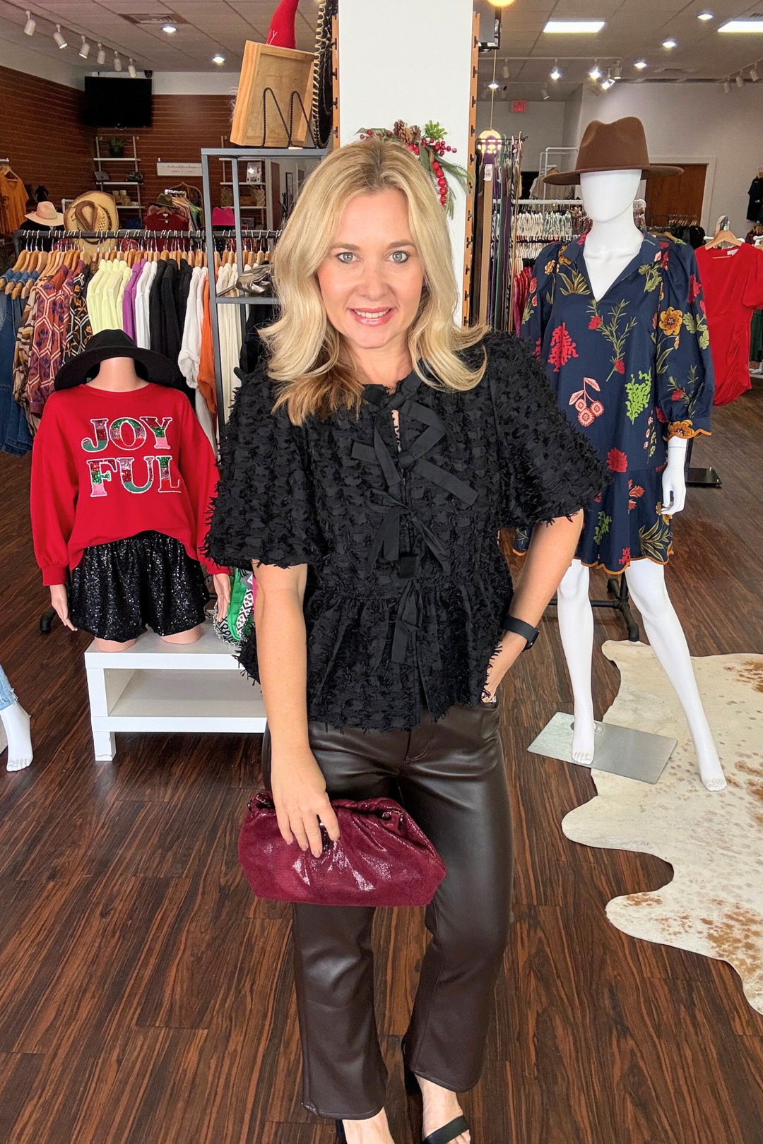 Elevate your everyday wardrobe with this modern textured top featuring a flattering peplum silhouette and playful bubble sleeves. The front showcases three delicate bow details that add dimension and personality to your look. 