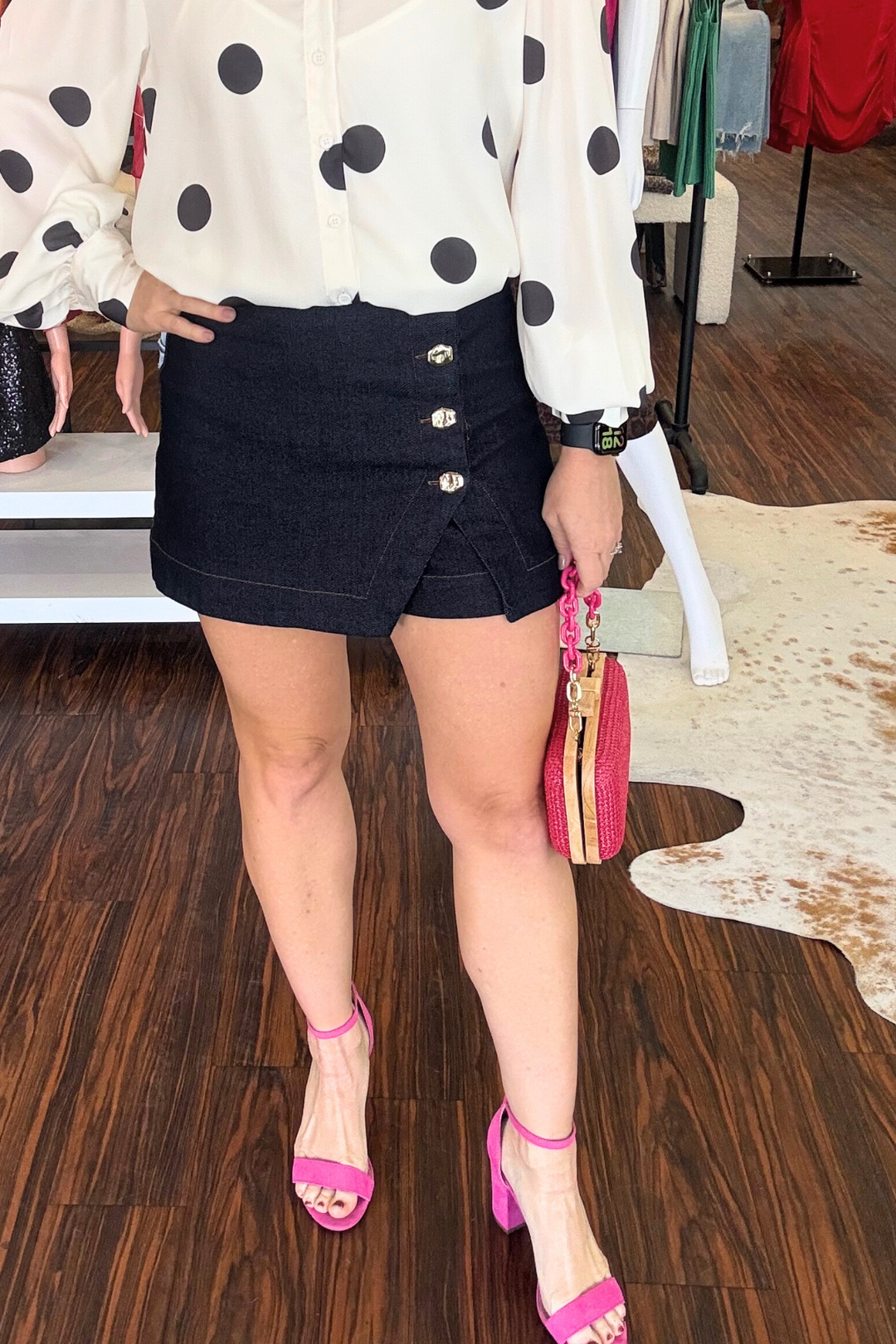 Sleek and versatile, this denim skort combines the comfort of shorts with the polished look of a skirt. Crafted from dark stretch denim that moves with you, it features an eye-catching button detail on the front and a practical side zipper for easy on-and-off. Perfect for transitioning from casual days to night-out ready in seconds. Model is wearing size small.&nbsp;