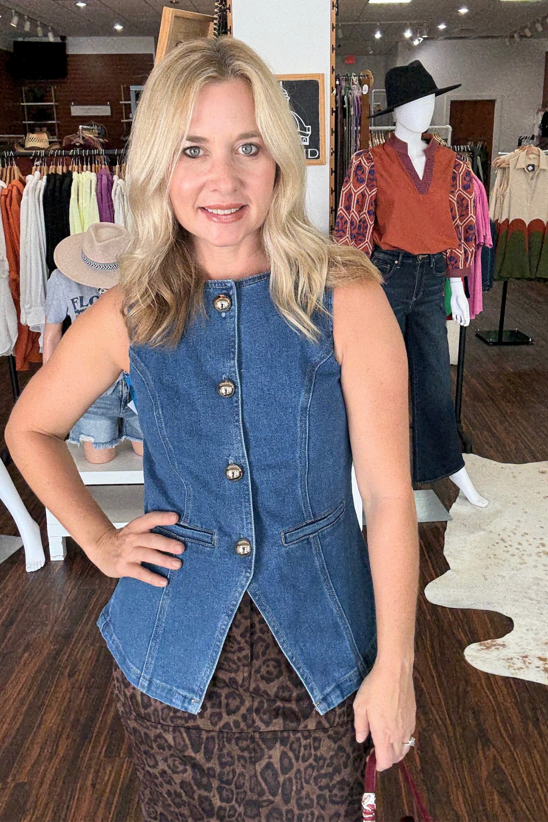 Denim vest featuring sleek gold button accents. The faux flat pockets add a clean, streamlined finish.