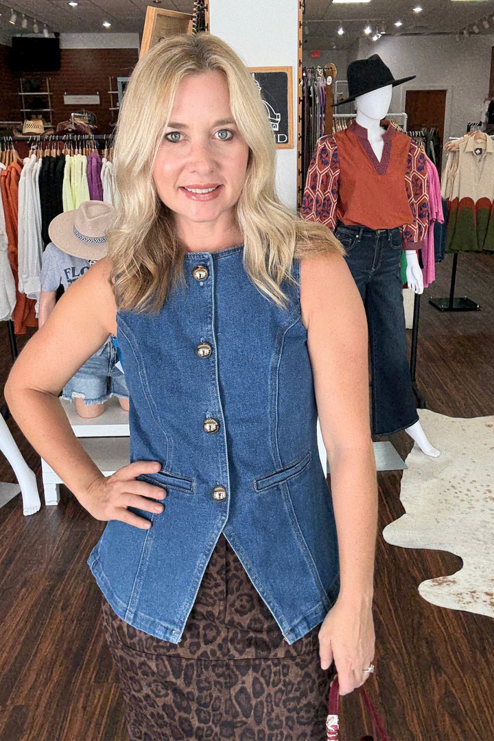 Denim vest featuring sleek gold button accents. The faux flat pockets add a clean, streamlined finish.