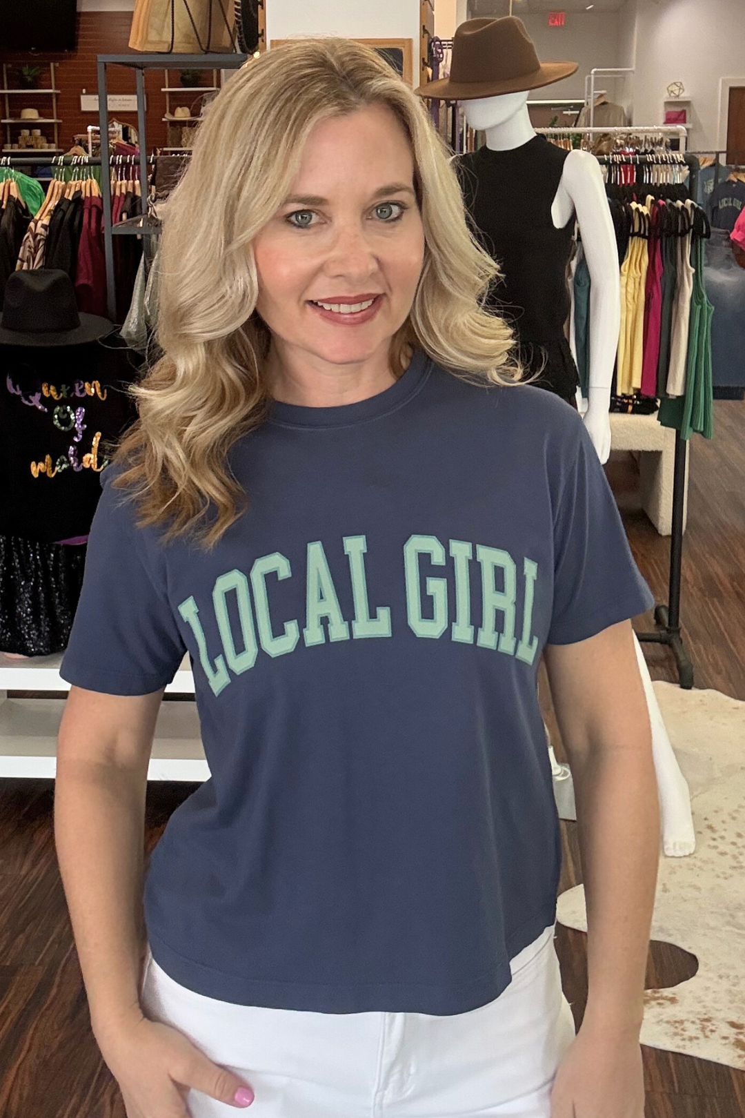 Celebrate your roots in this navy cropped tee featuring a bold "Local Girl" graphic in refreshing mint. The relaxed fit and cropped silhouette offer a contemporary take on casual style, perfect for pairing with high-waisted bottoms or layering over your favorite basics. A versatile wardrobe essential that speaks to community pride and effortless cool.