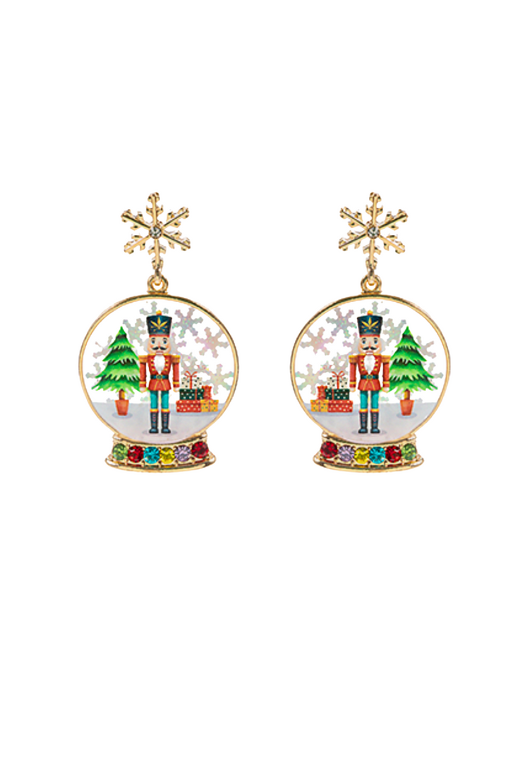 Pair of earrings with snow globe design featuring a nutcracker and Christmas tree on a white background.