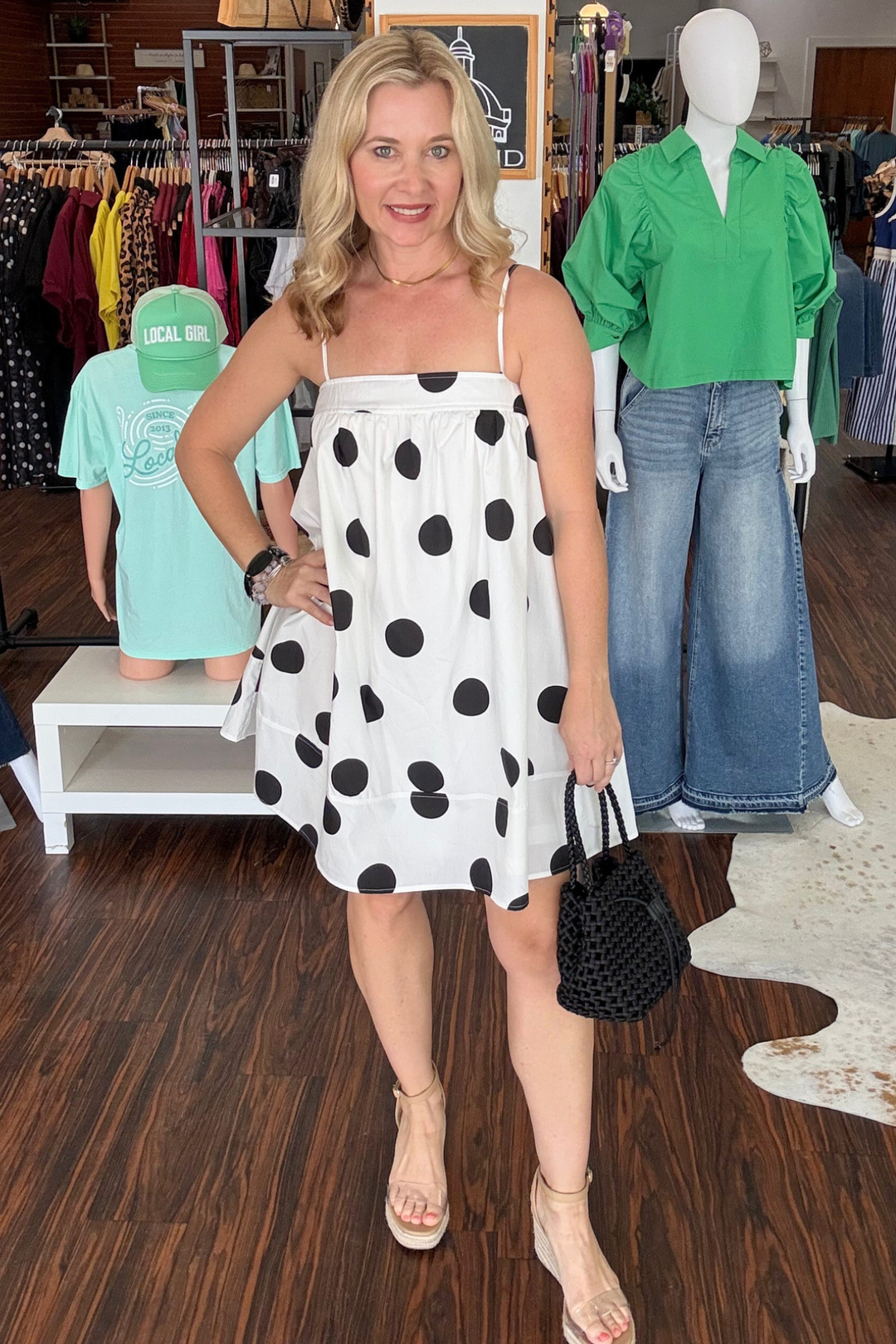 Effortless charm meets practical style with this playful baby doll mini dress. Featuring a classic white base adorned with black polka dots, it's a timeless pattern that works for any occasion. Adjustable spaghetti straps let you customize the fit, while the elastic chest detail creates a flattering silhouette. Hidden pockets add everyday functionality—perfect for keeping essentials close. Light, breezy, and undeniably cute, this dress transitions seamlessly from casual outing