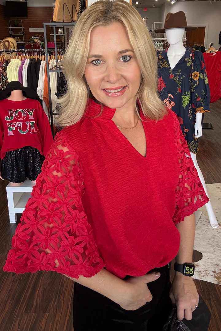 Elevate your holiday wardrobe with this striking red V-neck top, featuring delicate lace detailing on the 3/4 sleeves. The flattering neckline and lace accents create a sophisticated silhouette that transitions seamlessly from office to evening