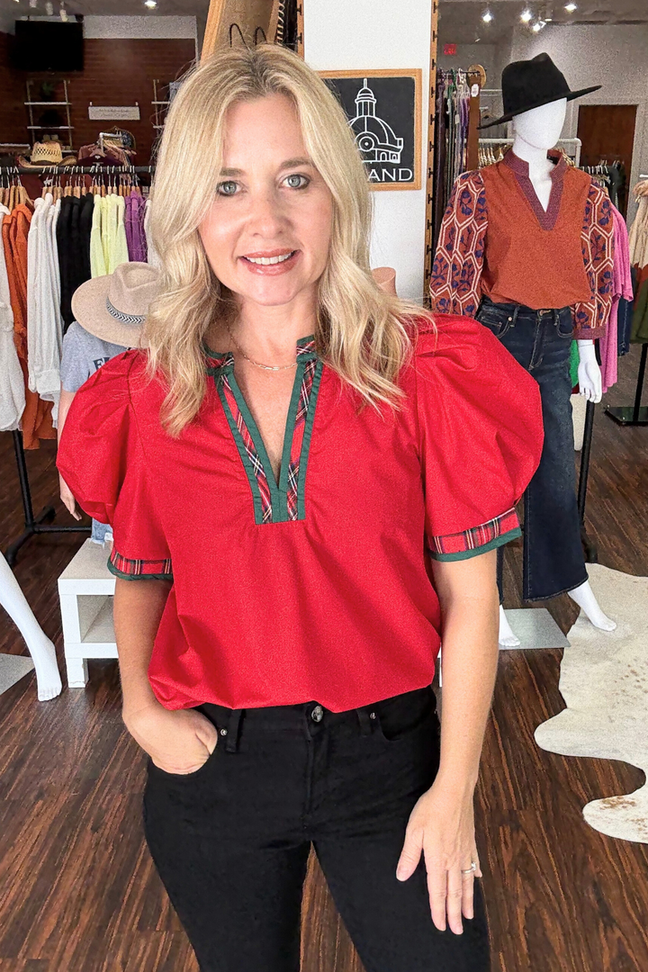This lightweight woven top features short puff sleeve with striking plaid contrast V-neck band for a modern edge. Its solid, non-sheer fabric ensures comfort and versatility. Perfect top for the holidays