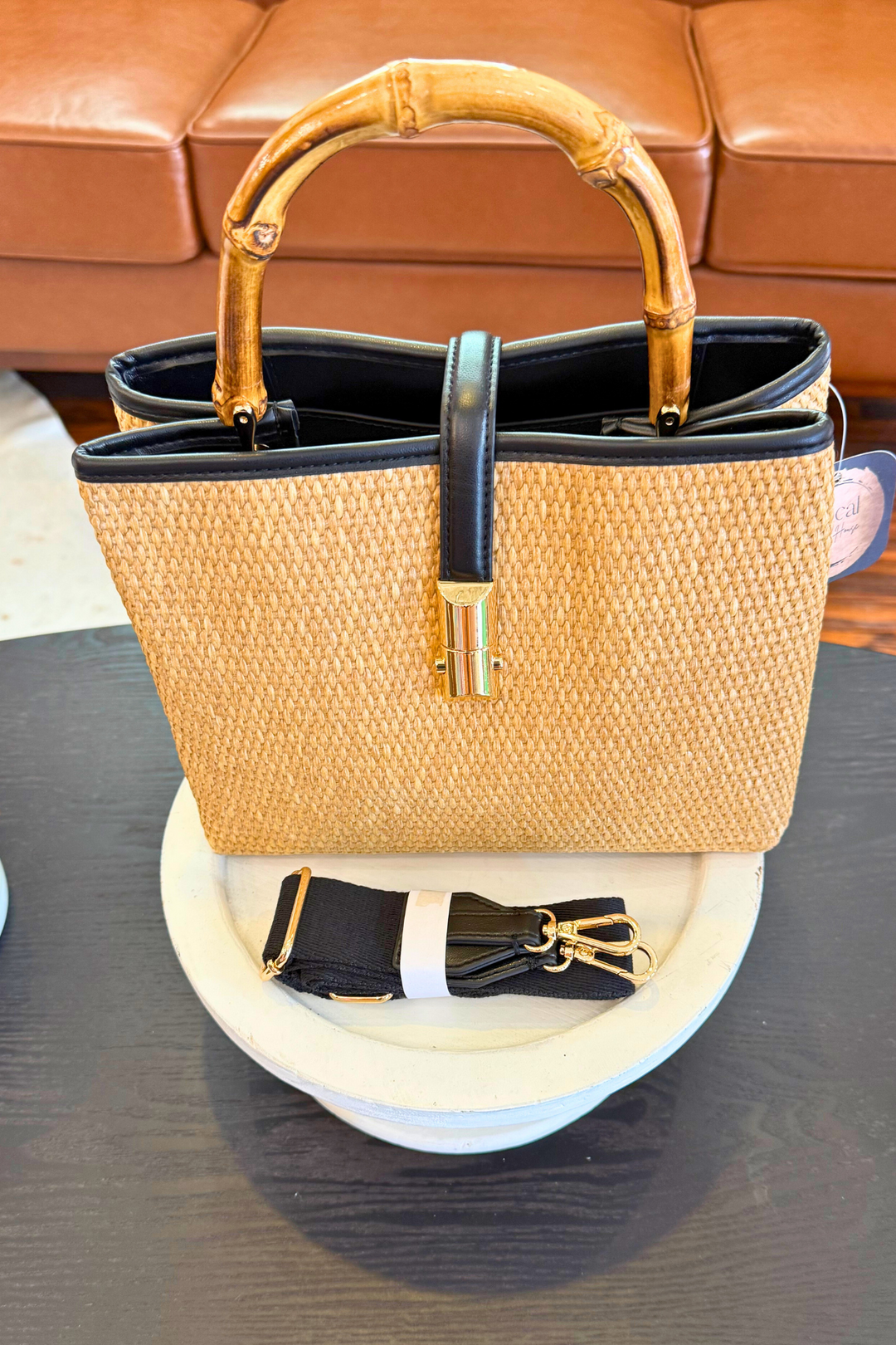 Straw Handbag features a faux wood handle and crossbody strap add versatility, making it a stylish and practical accessory.  